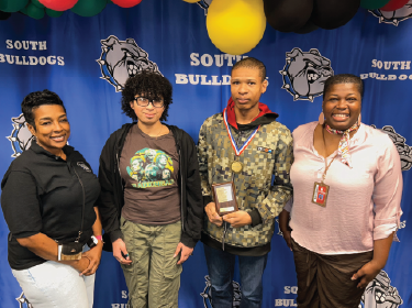 students standing with award